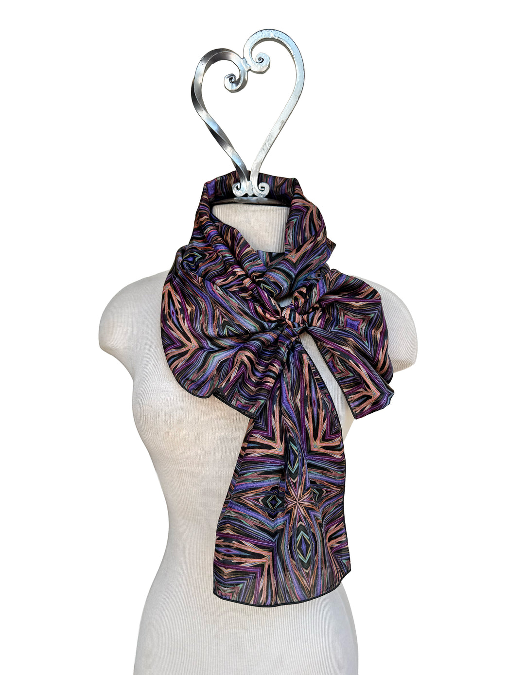Patterned scarf on a mannequin with a decorative hanger against a white background