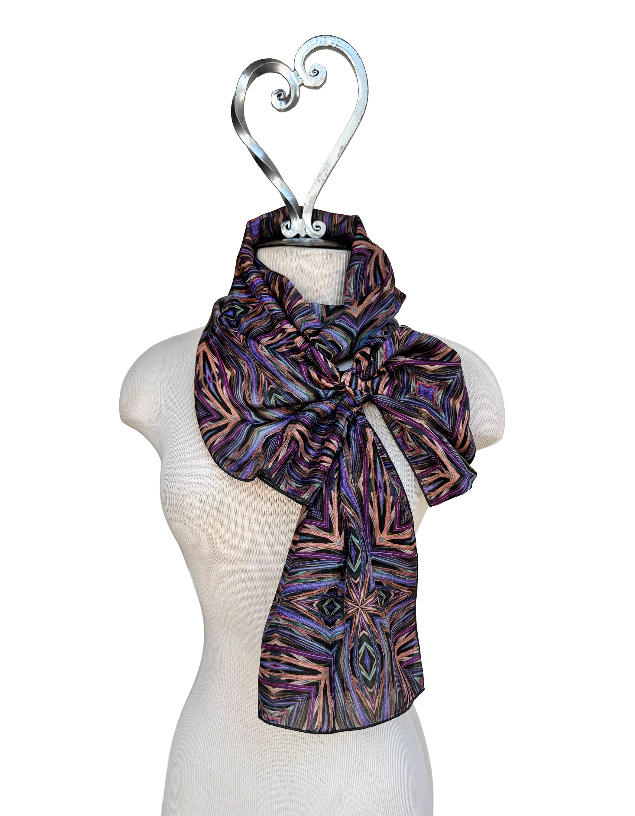 Patterned scarf on a mannequin with a decorative hanger against a white background