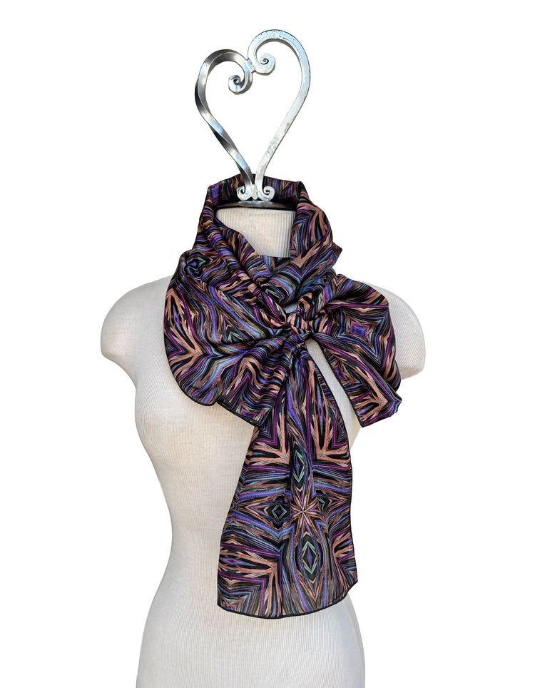 Patterned scarf on a mannequin with a decorative hanger against a white background