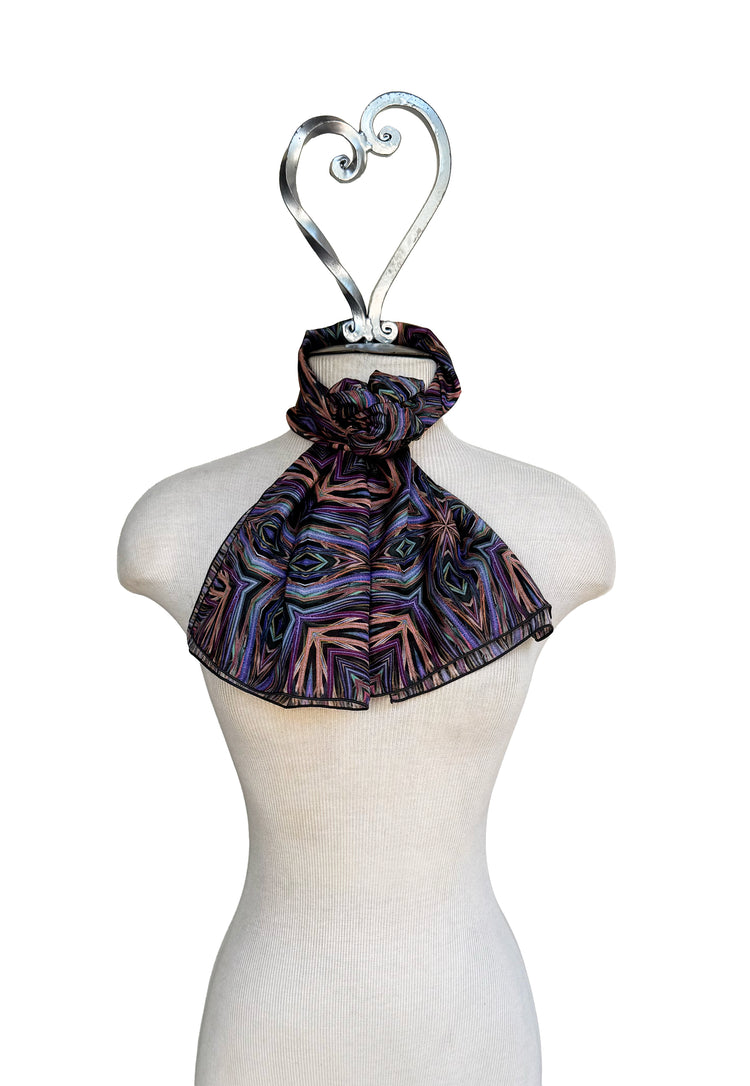 Patterned scarf on a mannequin with a decorative hanger against a white background