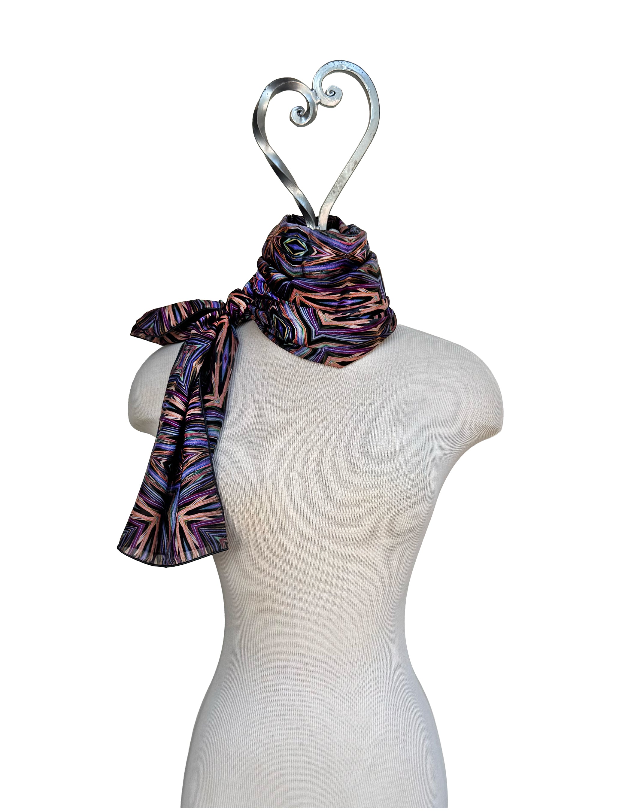 Mannequin wearing a patterned scarf with a decorative hanger on a white background